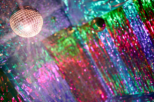 Mirror disco ball on shiny background with bokeh lights. Holiday abstract image with defocused lights. Copy space