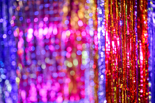 Multicolored shiny background with bokeh lights. Holiday abstract image with defocused lights. Copy space