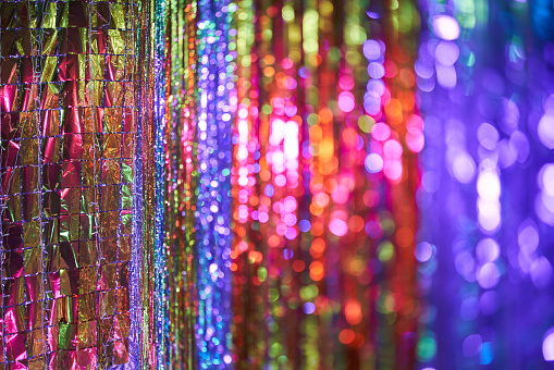 Multicolored shiny background with bokeh lights. Holiday abstract image with defocused lights. Copy space
