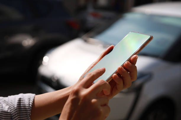 istock Young woman using mobile app to hail a ride close up 1442209752