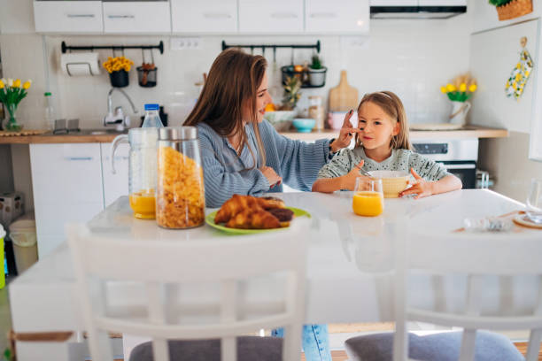 istock Front view of mother and daughter sitting at the dining table during breakfast 1442209806