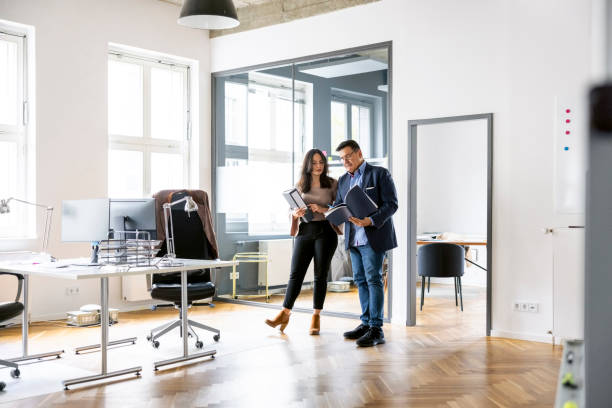 istock Two business professionals discussing over project report in office 1442210143