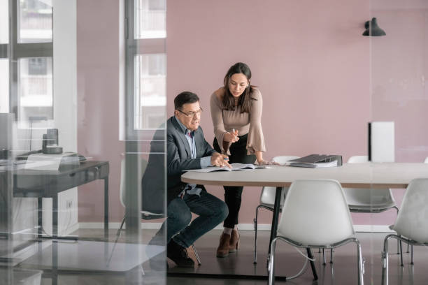 istock Two business professionals discussing over reports in office 1442210180