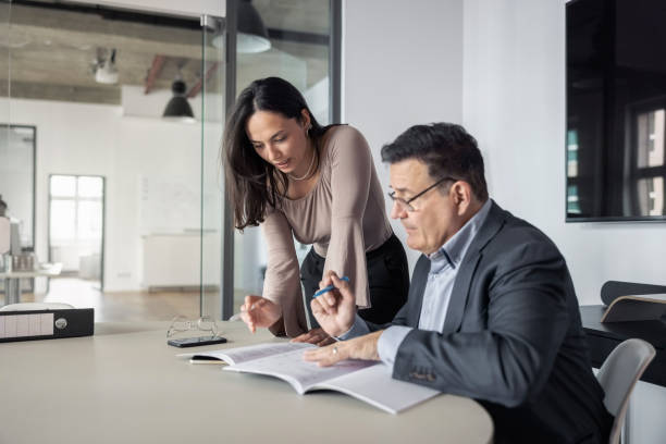 istock Two business professionals discussing over project report in office 1442210201