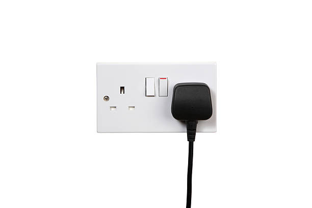 Socket on British socket and black plug. Socket turned on. isolated on white three pin plug stock pictures, royalty-free photos & images