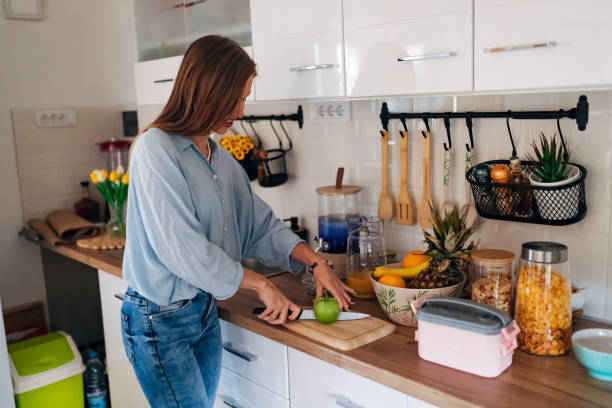 istock A woman cuts an apple while standing in the kitchen and preparing school lunch for her daughter 1442212083