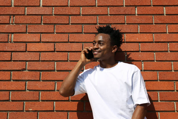 istock Young black man posing over the brick wall. 1442214333