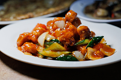 Chinese sweet and sour pork. Deep fried pork cube stir-fried in sweet and sour sauce with onion and cucumber
