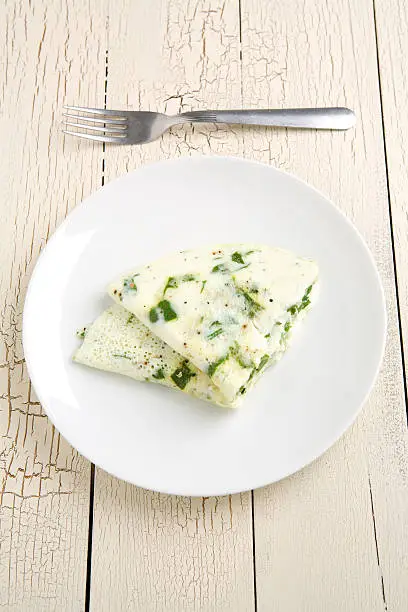 Egg white and spinach omelet on a white plate