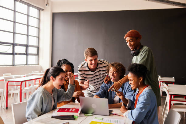 istock Students watching something on a laptop in a classroom and cheering 1442219624