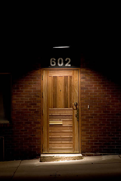 istock Lit up single wooden door. 602 144221990