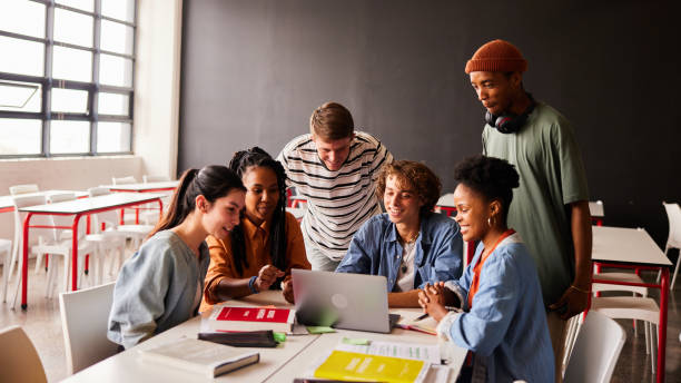 istock Students smiling at something streaming on a laptop in a classroom 1442220124
