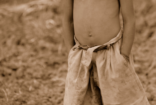 The photograph tries to capture the elegance and optimistic attitude of this poor boy who works in the fields  of a remote village in India. Notice the way the boy stands with his two hands inside his trousers.