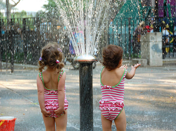 Toddlers Cooling Off Under the Sprinkler stock photo