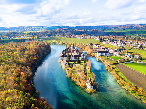 Rheinau, Switzerland - November 11. 2022: Aerial view of the Rheinau Abbey Islet on Rhine river in autumnal splendid colors, Switzerland