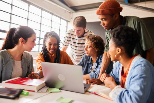 istock Smiling students working together on a laptop at a classroom table 1442225459