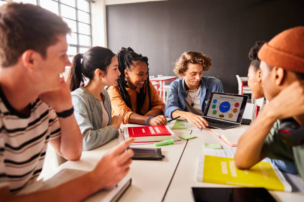 istock Smiling students working on a marketing project on a laptop at school 1442225661