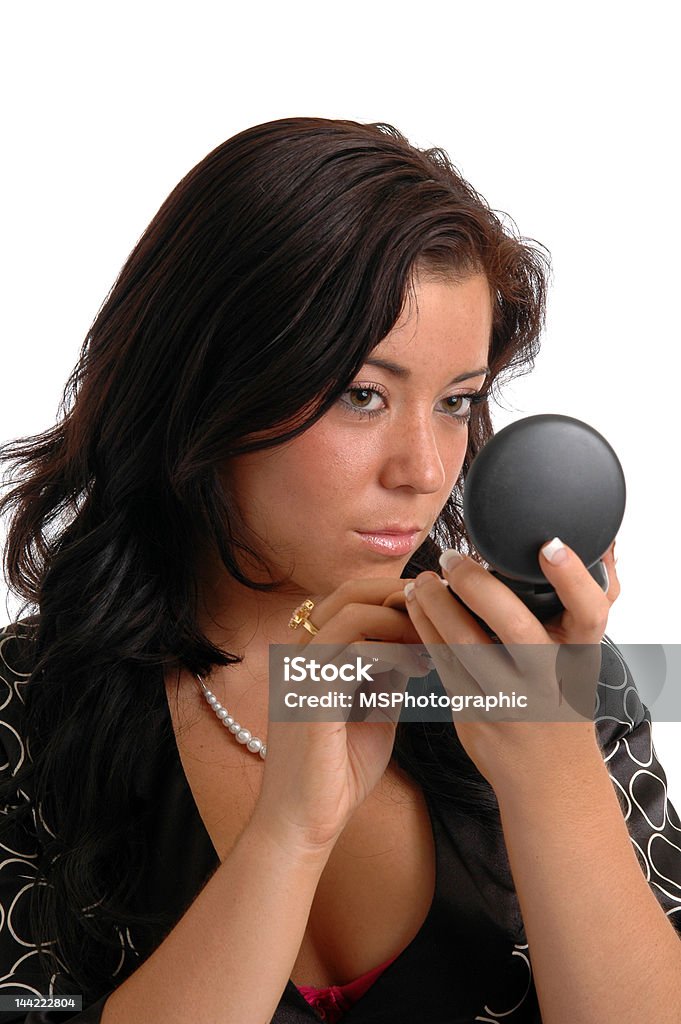 Touchup A pretty young woman touching up her makeup with a compact Adult Stock Photo