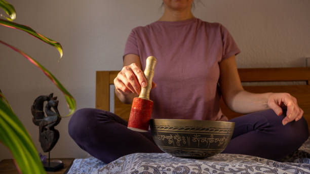 zu hause meditieren, tibetische klangschale spielen - music wellbeing rin gong bowl stock-fotos und bilder