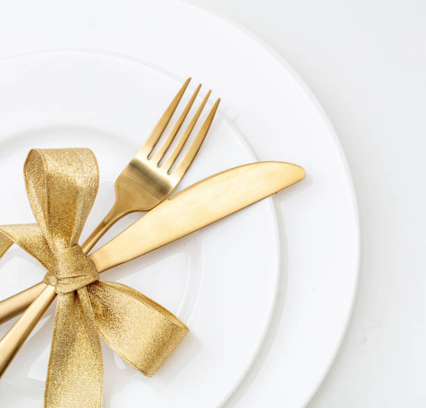 istock Christmas table setting top view. Gold cutlery and decoration on white dishes, 1442231292