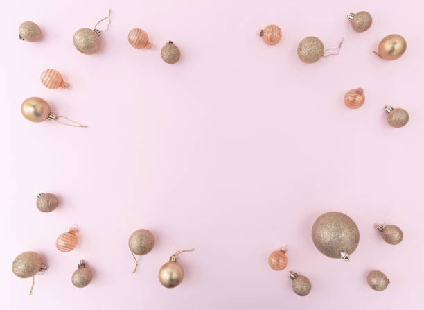 istock Christmas gold baubles frame on pink color background, top view. 1442231352