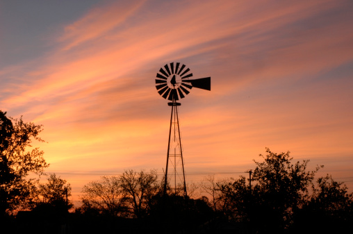 Windmill with the sunrise in the background. The picture was takenin the town of Fredericksburg, Texas.
