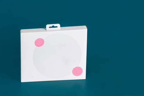 istock A blank white cardboard box with two small pink decorative circles around a large gray circle on a colorful blue studio background with copy space. 1442236549