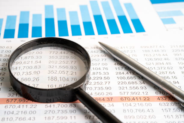 Magnifying glass on charts graphs spreadsheet paper. Financial development, Banking Account, Statistics, Investment Analytic research data economy.