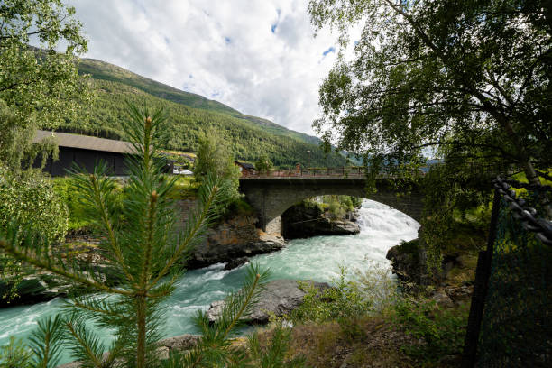 istock emerald green water in a bubbling river over which there is a stone bridge and green trees growing along the sides 1442238021