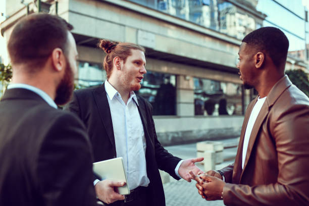 istock Ginger Businessman Explaining Plans And Ideas To Multiethnic Colleagues After Work 1442240077