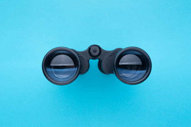 Binoculars isolated on blue background. Front view. Binoculars isolated on blue background. binoculars stock pictures, royalty-free photos & images