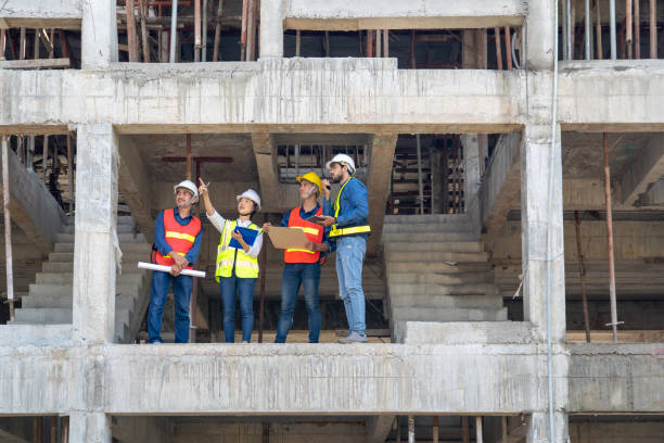 el equipo de ingeniero civil junto con el operador de seguridad inspeccionan la infraestructura del progreso de la construcción del edificio en el sitio - manual worker fotos fotografías e imágenes de stock