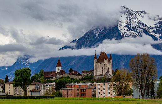 Castle of Thun, Switzerland - April 24, 2022: medieval castle with snow covered Alps in the background