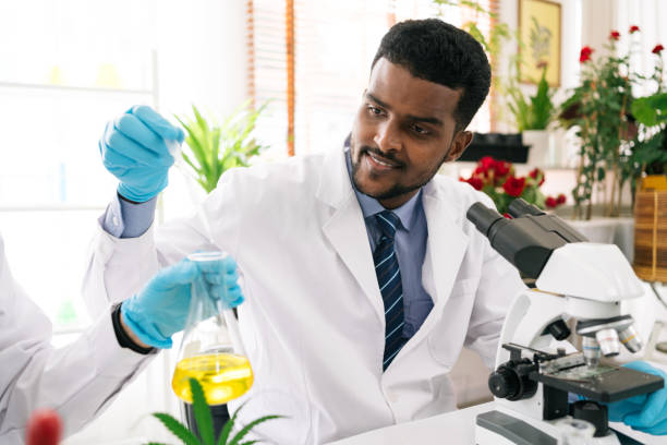 istock African man scientist researcher use a lab dropper to drip a substance into a conical flask for analysis of liquids in the lab. Scientist working with a dropper and a conical flask. 1442244949