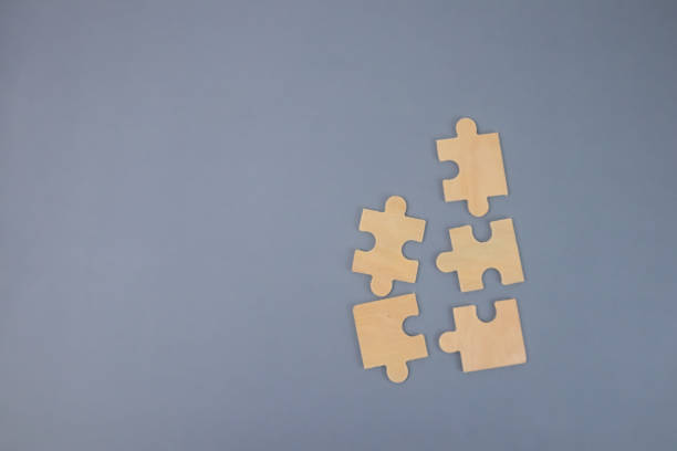 istock Several wooden puzzle pieces on a gray background. 1442246654