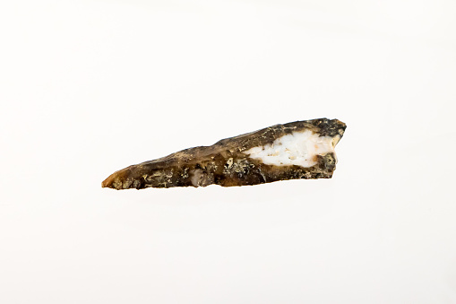 Ancient stone knife blade on white background