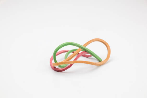 Three rubber bands in yellow, green and red in abstract shape isolated on white background.
