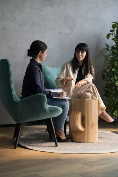 istock Two women talking seated on armchairs in office workspace 1442252248