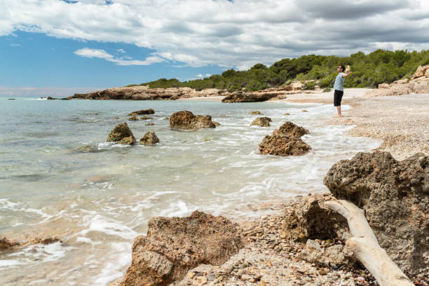 istock Happy standing man with open arms at a idyllic mediterranean beach. 1442253282