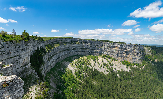 Creux du Van, which in archaic French means hollow of wind, is a rock formation eroded naturally by water, forming a rock amphitheater of 1,400 m in length, with walls about 150 in height. It is located near the village of Noiraigue in the Swiss canton of Neuchâtel, in the Jura Mountains.