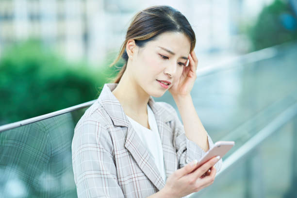 istock woman looking at a smartphone screen with a troubled expression 1442255254