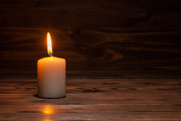 istock burning candle on wooden background in minimalist room interior, copy space 1442256148