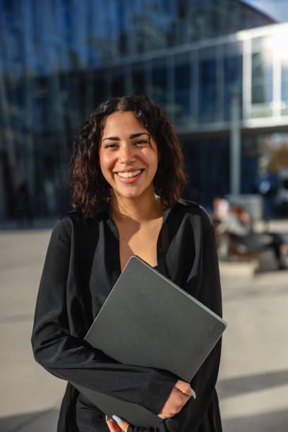 istock Attractive Young Latin-American Lady Smiling While Carrying Laptop 1442256501