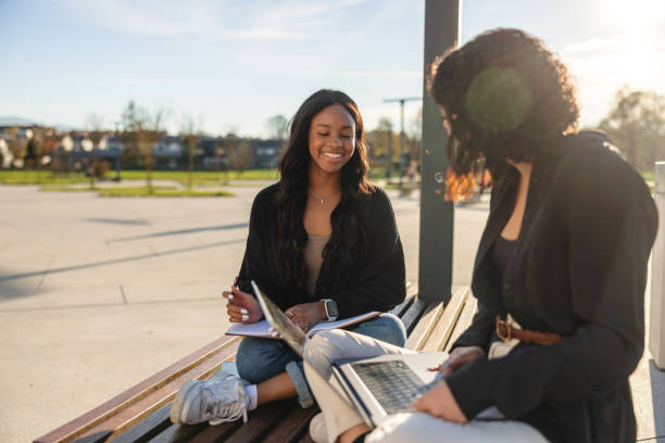 istock Female University Students Sitting Outdoors On Campus Studying 1442256504