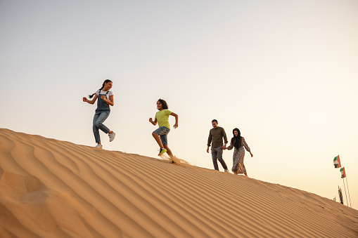 Tourists enjoying their vacation at sunset in Dubai desert.