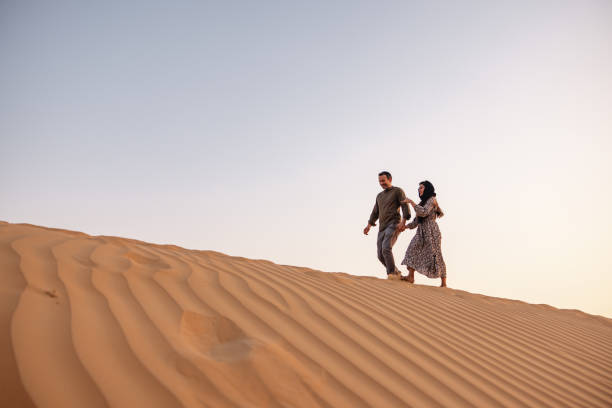 istock Middle Eastern Tourists Walking At Sunset In Dubai Desert 1442260809