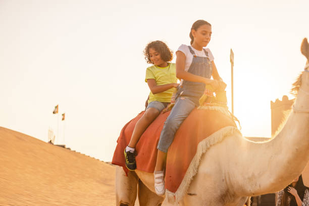 istock Young Children Riding A Camel In Dubai At Sunset 1442261326