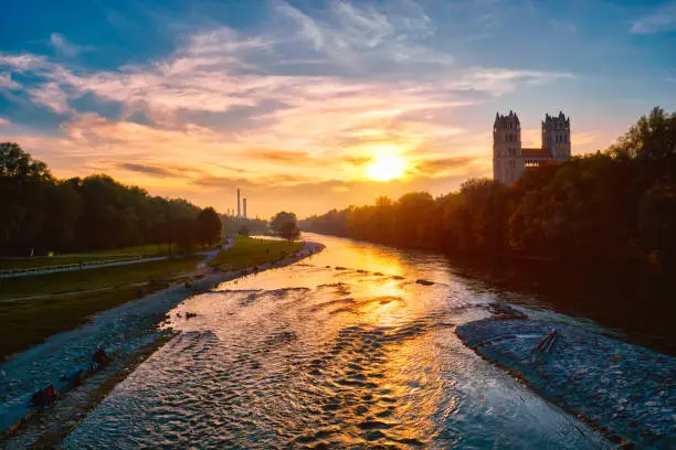 Munich view - Isar river, park and St Maximilian church from Reichenbach Bridge on sunset. Munchen, Bavaria, Germany.