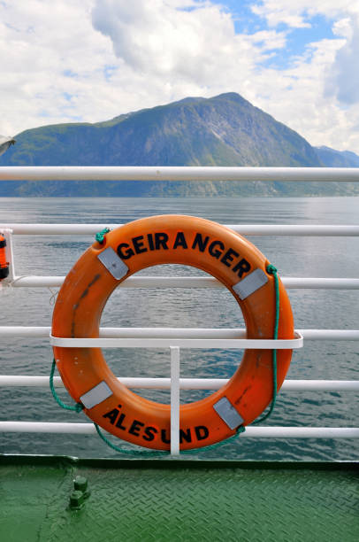 uma boia salva-vidas laranja em uma balsa através de um fiorde na noruega - more objects - fotografias e filmes do acervo