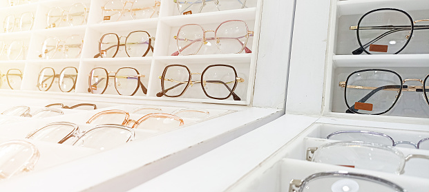 Several pictures of eyeglasses are placed on the shelf.